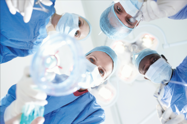 Čtyři chirurgové léčí pacienty s respiračními pomůckami